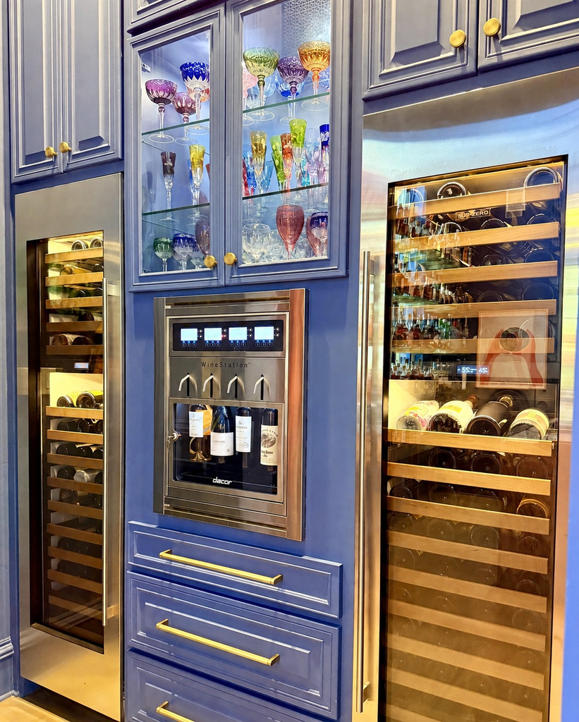 Blue cabinetry with built-in wine refrigerators and a wine dispenser