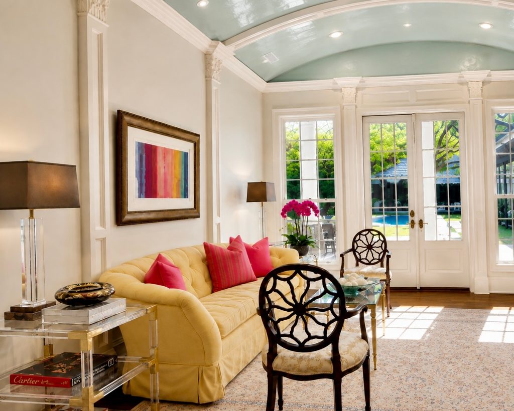 Sunroom with a yellow sofa, barrel-vaulted ceiling, and French doors