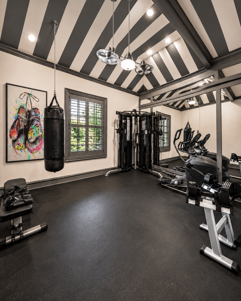 Home gym with a striped ceiling, punching bag, and strength equipment