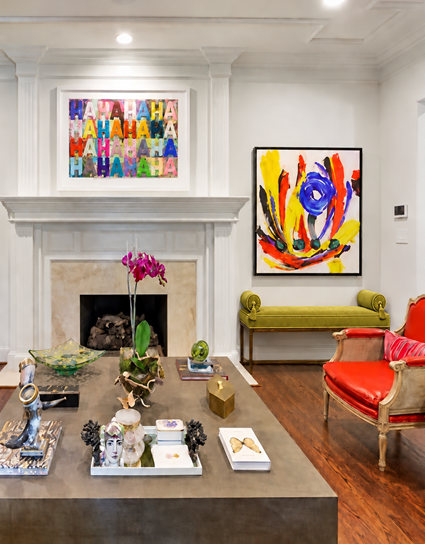 Living room with a white fireplace surround, colorful modern artwork, and a chartreuse settee