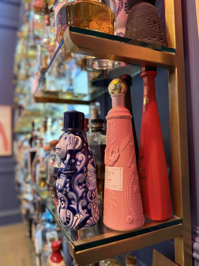 Decorative bottles on glass shelves in a home bar